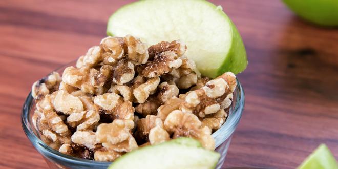 A bowl of chopped walnuts and green apple slices