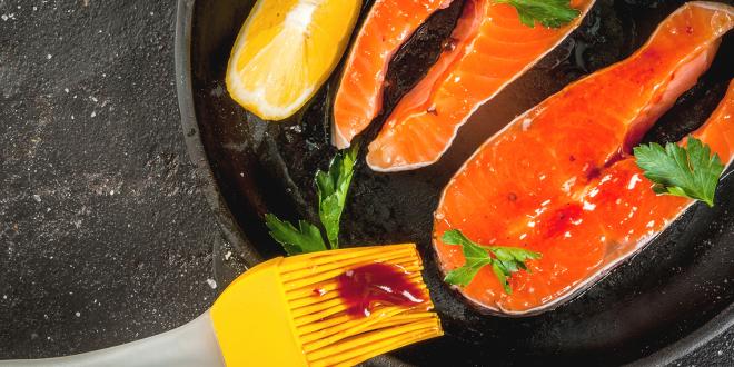 salmon being slathered with sauce for the grill