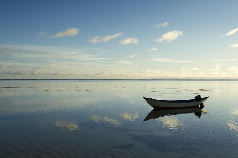 a small boat floating in still and empty waters