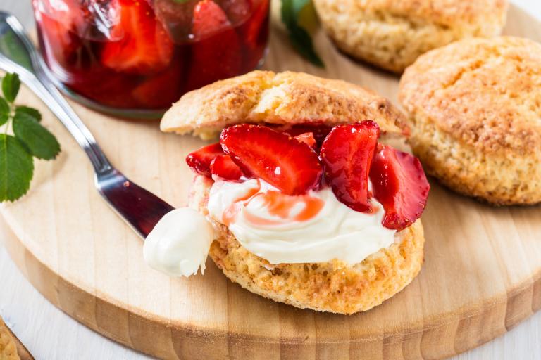 Shortcake biscuit cut open with strawberries and whipped cream in the middle.