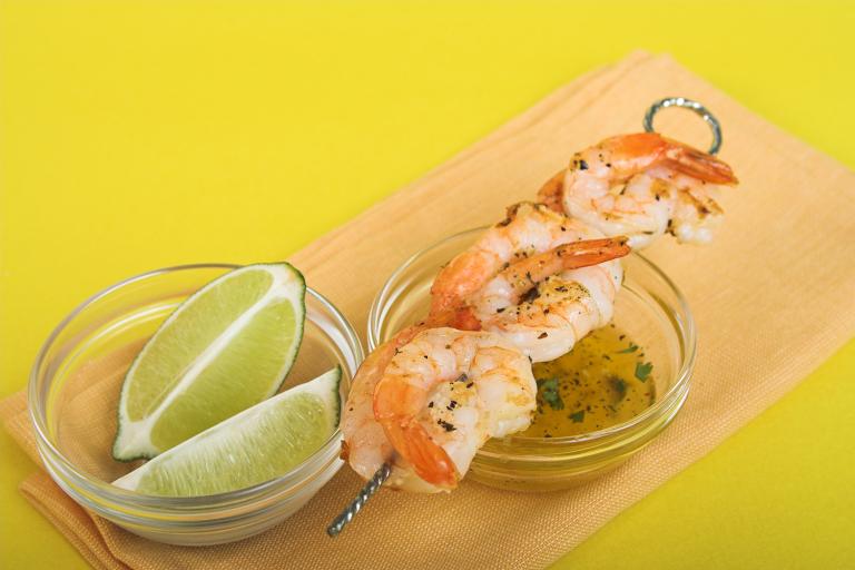 shrimp on the skewer with limes and a butter sauce