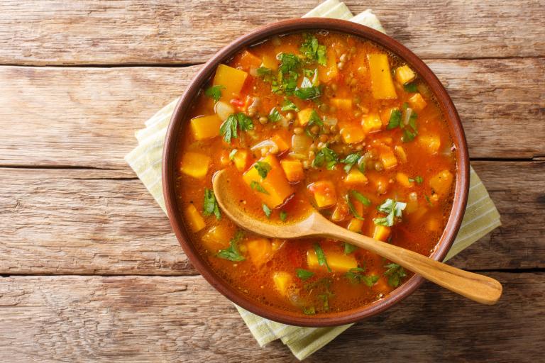 Traditional thick sweet potato soup with lentils close up in a bowl on the table.